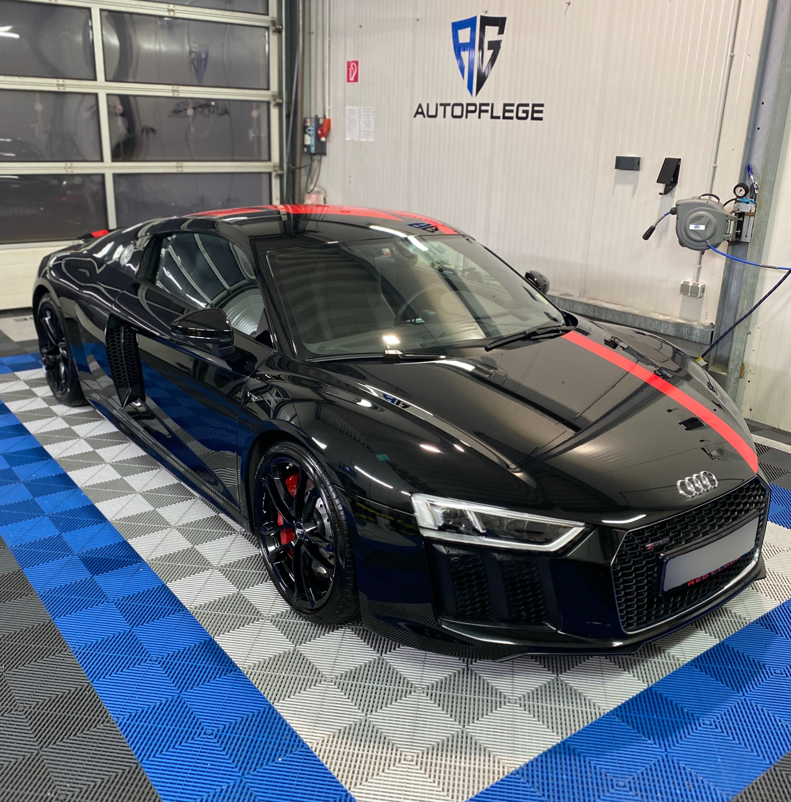 Schwarzer Audi R8 mit rotem Streifen über Motorhaube und Dach, von schräg vorn