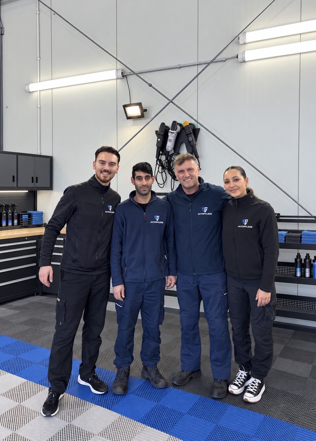 Das Team von AG Autopflege in Arbeitskleidung mit Logo in der Zentrale