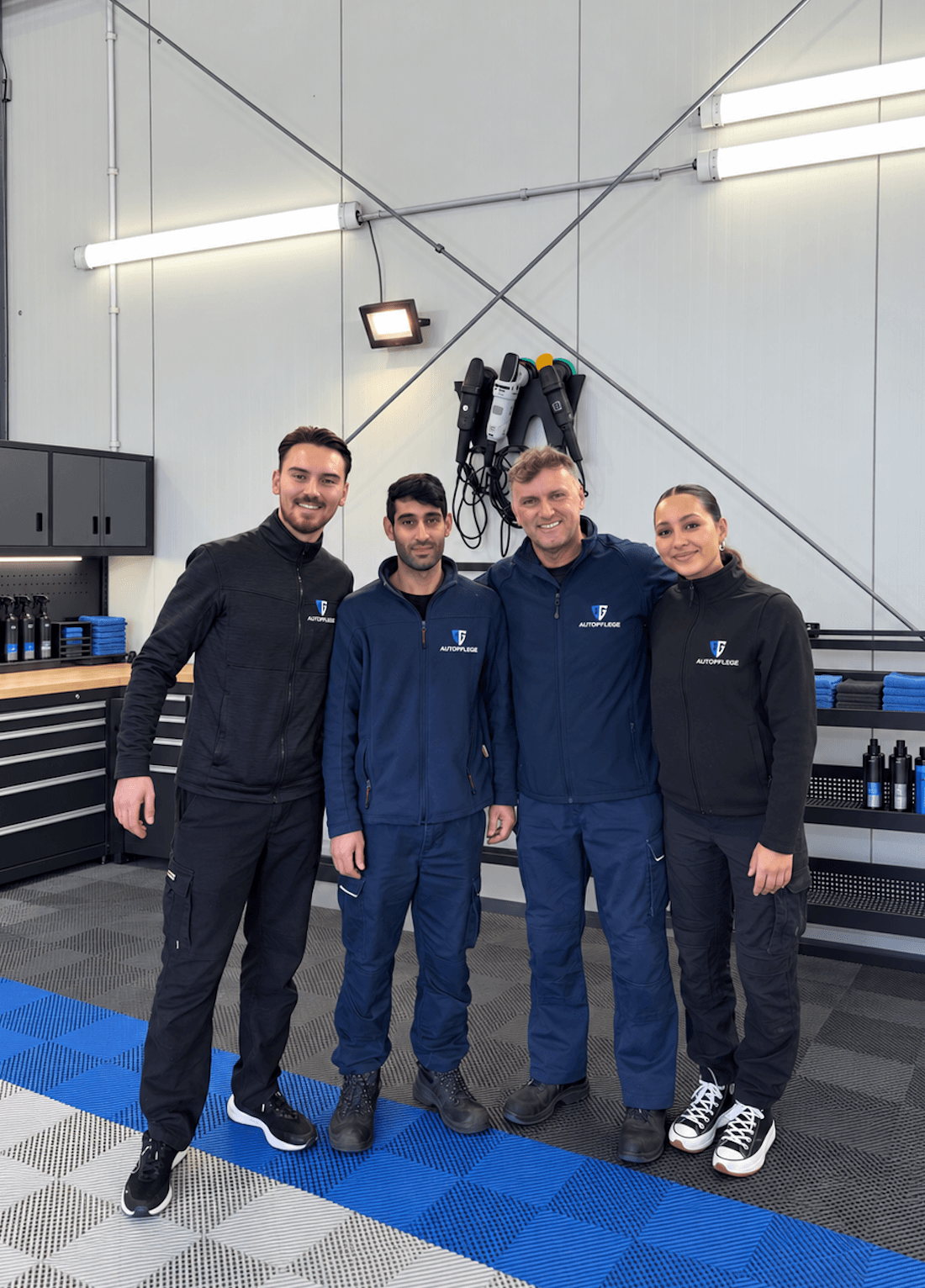 Das Team von AG Autopflege in Arbeitskleidung mit Logo in der Zentrale